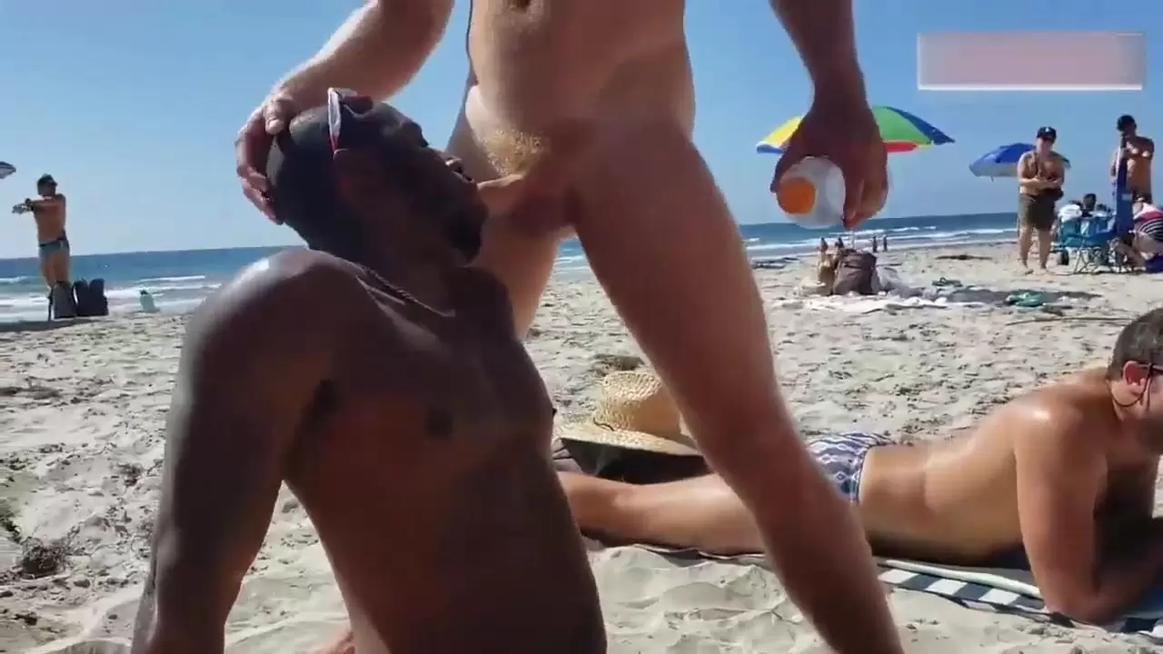 Gay noir et blanc sur une plage publique.Interracial en plein air regarder en ligne photo photo